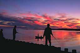 Sunset with fishermen on pier